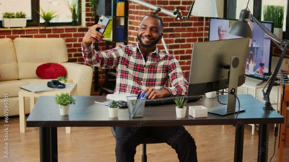 Happy cheerful african american man taking selfie while smiling and showing thumbs up sign. Man in nice stylish modern house capturing photo using smartphone while remotely working from home Happy cheerful african american man taking selfie while smiling and showing thumbs up sign. Man in nice stylish modern house capturing photo using smartphone while remotely working from home