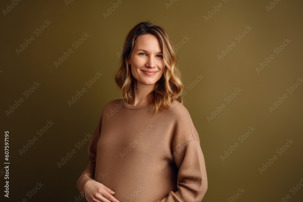 Portrait of a smiling young woman in a beige sweater on a green background Portrait of a smiling young woman in a beige sweater on a green background