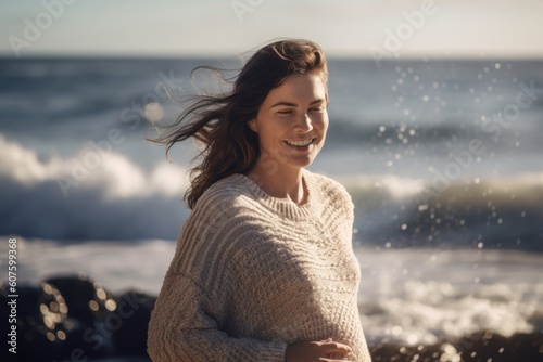 Portrait of smiling young woman standing on the beach at autumn day © Robert MEYNER