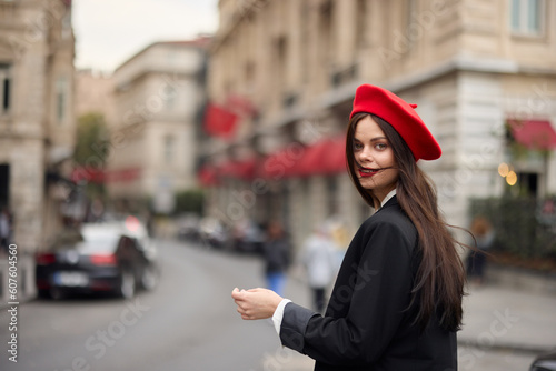 Fashion woman portrait smile teeth standing on the street in the city background in stylish clothes with red lips and red beret, travel, cinematic color, retro vintage style, urban fashion lifestyle.