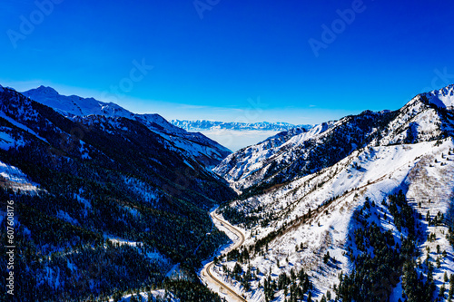 Alpine Serenity: Majestic Snowy Mountain Road Overlooking Salt Lake Valley