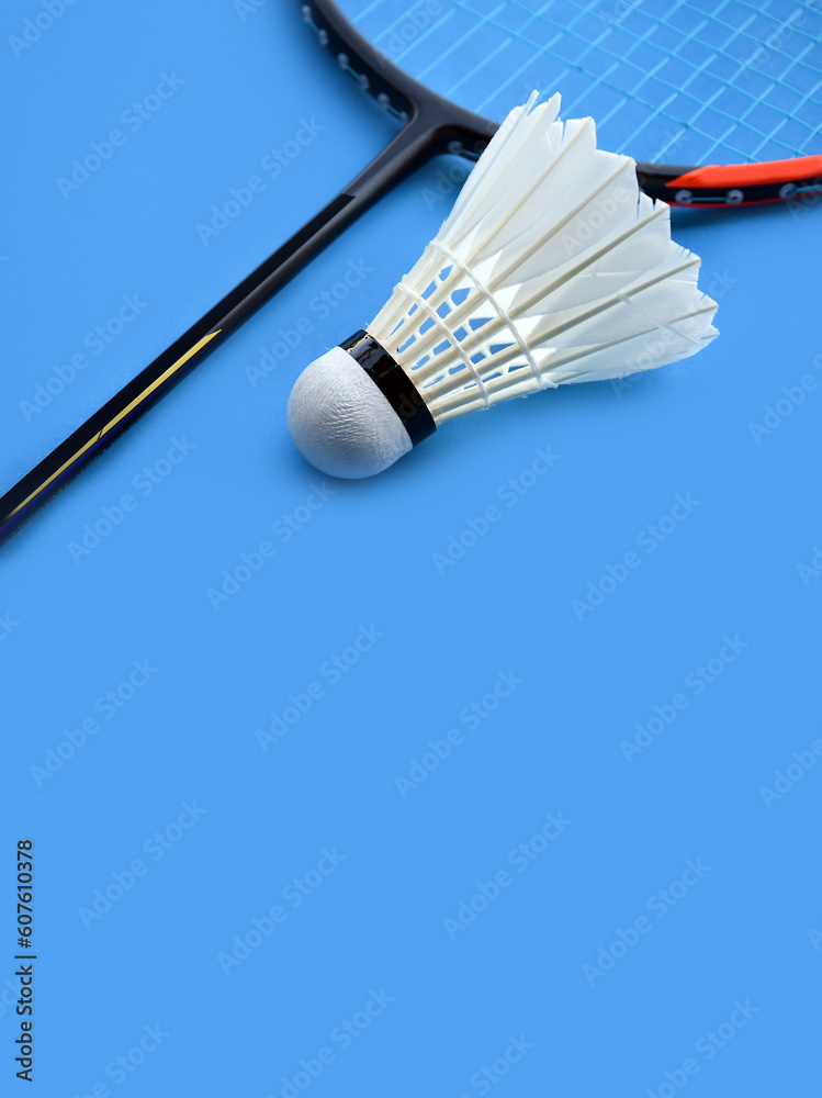 Cream white badminton shuttlecock and racket on floor in indoor badminton court, copy space, soft and selective focus on shuttlecocks. Cream white badminton shuttlecock and racket on floor in indoor badminton court, copy space, soft and selective focus on shuttlecocks.