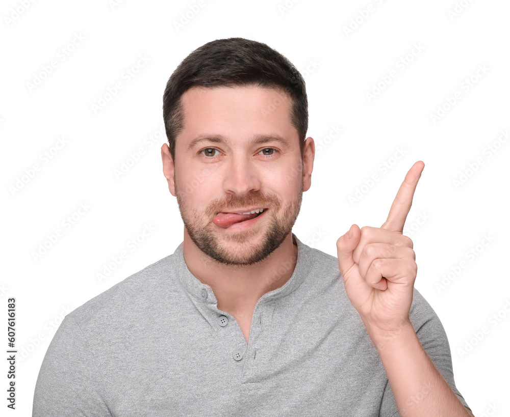 Happy man showing his tongue and pointing at something on white background Happy man showing his tongue and pointing at something on white background