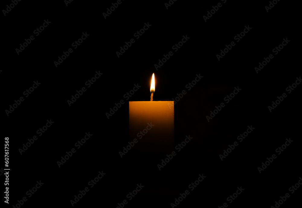 One burning wax candle on black background One burning wax candle on black background