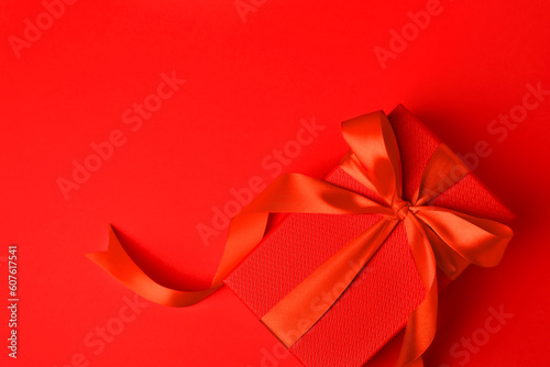 Beautiful gift box with bow on red background, top view. Space for text