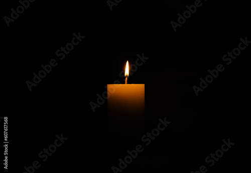 One burning wax candle on black background