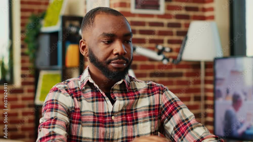 Remote worker focused on finishing dull monotonous job tasks while staying at home in nice apartment. African american teleworker happy with work done, slow motion close up Remote worker focused on finishing dull monotonous job tasks while staying at home in nice apartment. African american teleworker happy with work done, slow motion close up