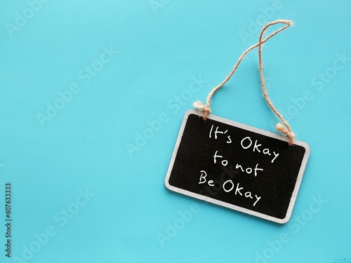 Chalkboard on blue copy space background with handwriting IT\'S OKAY TO NOT BE OKAY, means feelings and emotions expressing are valid no matter what, it is normal to say you are not ok