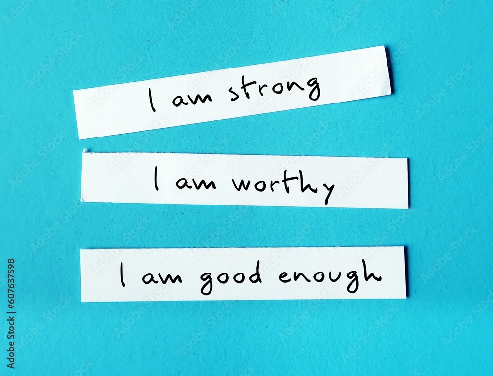 Three note paper on blue background with handwritten text I AM STRONG, I AM WORTHY, I AM ENOUGH - powerful self talk positive affirmations to boost self confidence self esteem Three note paper on blue background with handwritten text I AM STRONG, I AM WORTHY, I AM ENOUGH - powerful self talk positive affirmations to boost self confidence self esteem
