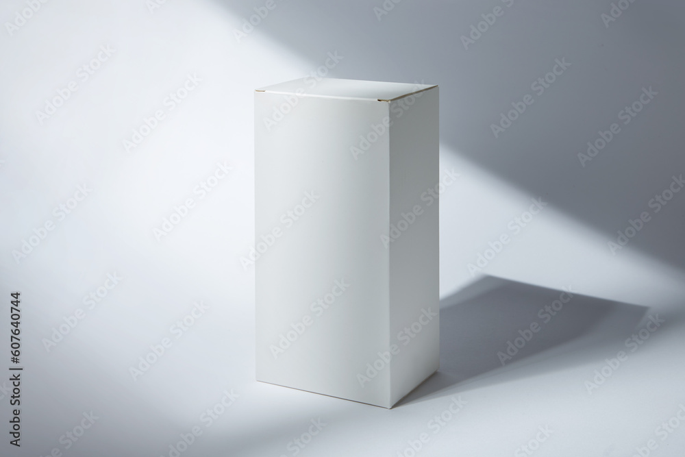 White paper box mockup in sunlight with shadow on white background. White paper box mockup in sunlight with shadow on white background.