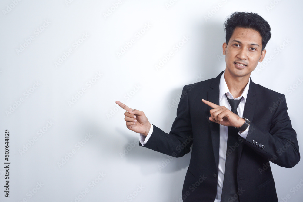 Young handsome Asian man wearing business clothes smiling and looking at the camera pointing with hands and fingers to the side.