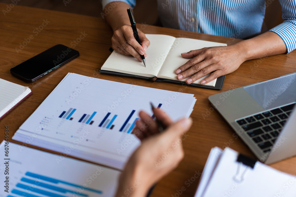 Close up of businessman is explaining business data and new project to partners and writing notes Close up of businessman is explaining business data and new project to partners and writing notes
