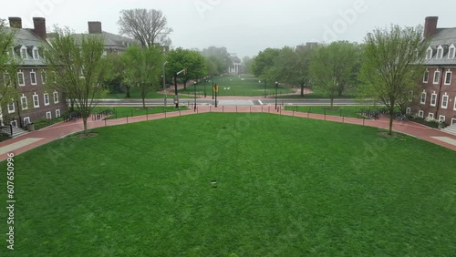 Aerial flyover academic lawns on foggy college campus. Green spaces for students to relax and colonial revival style dorms on foggy spring morning. Establishing shot at University of Delaware. photo