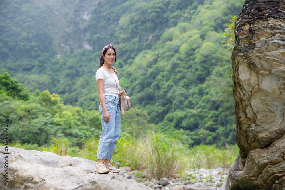 Naklejka premium Woman stand on the rock into forest