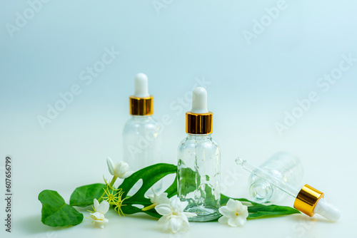 A transparent cosmetic bottle decorated with lovely white leaves and flowers.