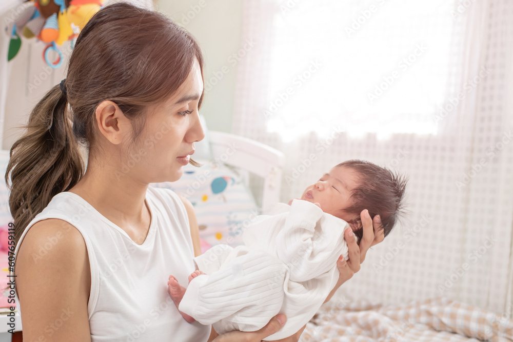 happy loving family. mother playing with her baby hugging in the bedroom , portrait of asian mother playing with newborn baby, health care family love together. asian girl lifestyle.. happy loving family. mother playing with her baby hugging in the bedroom , portrait of asian mother playing with newborn baby, health care family love together. asian girl lifestyle..