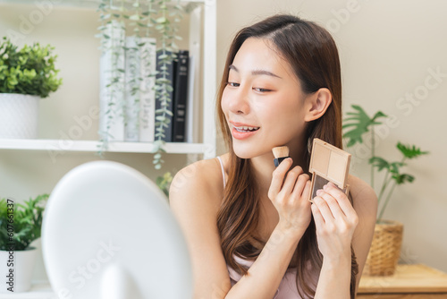 Contour and highlight beauty concept, happy smiling beautiful asian young woman, girl doing shading face make up apply blush on cheek, different shades of skin base, foundation. Perfect complexion.