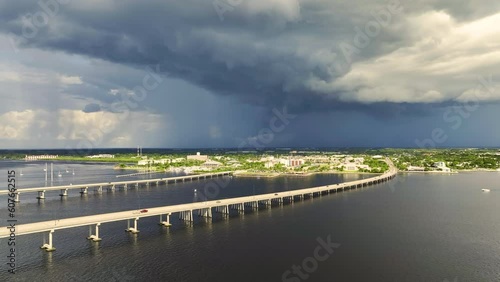 Stormy clouds forming from evaporating humidity of ocean water before thunderstorm over traffic bridge connecting Punta Gorda and Port Charlotte over Peace River. Bad weather conditions for driving photo