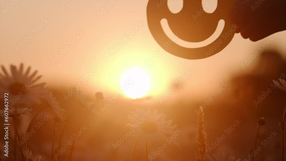 Child hand holding happy smile face paper cut on background amazing sunset, good feedback rating, positive customer review, experience, satisfaction survey, wellness, world mental health day concept