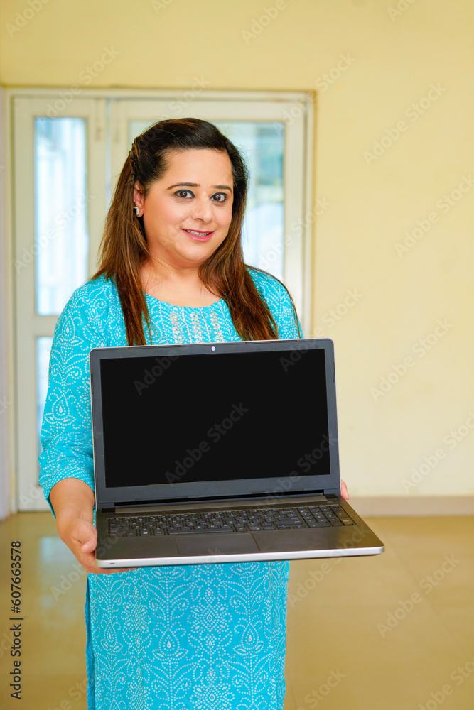 Naklejka premium Indian woman showing laptop screen at office.