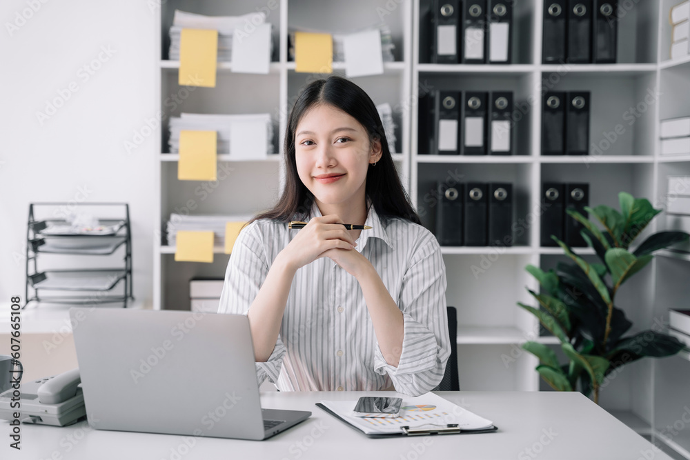 Female asian sitting at the desk, looking to camera. Female asian sitting at the desk, looking to camera.
