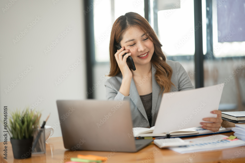 Asian business woman Working at the office, use notebook, smart phone Asian business woman Working at the office, use notebook, smart phone