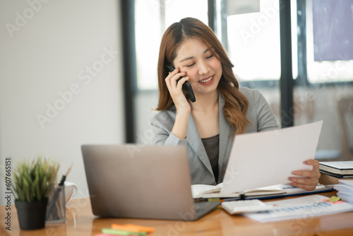 Asian business woman Working at the office, use notebook, smart phone