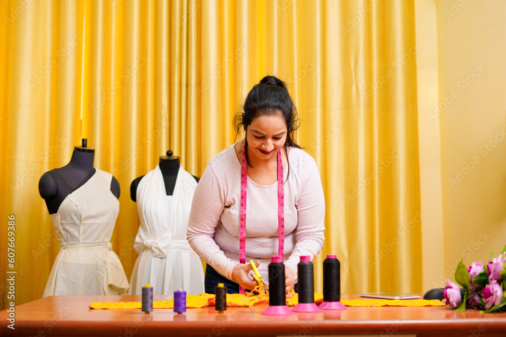 Indian female fashion designer working at her shop