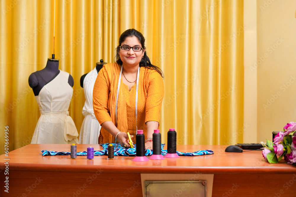 Indian female fashion designer working at her shop