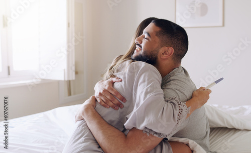Couple, hug and happy for pregnancy test in bedroom, home and support to celebrate good news. Excited man, woman and partner hugging in celebration of pregnant results, future family or ivf fertility photo