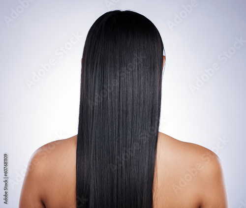 Back, hair care and woman with shine, salon and confident girl against a studio background. Female person, cosmetics or model with treatment, grooming or healthy scalp with luxury, glow and self care