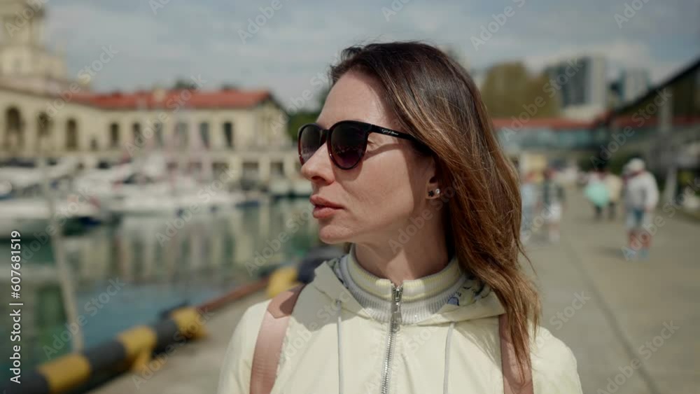 lonely pensive middle-aged woman walking on beautiful pier with moored yachts, tourist in marina lonely pensive middle-aged woman walking on beautiful pier with moored yachts, tourist in marina