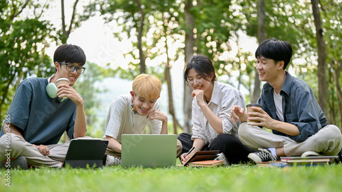 A group of diverse young Asian college students enjoy discussing their project