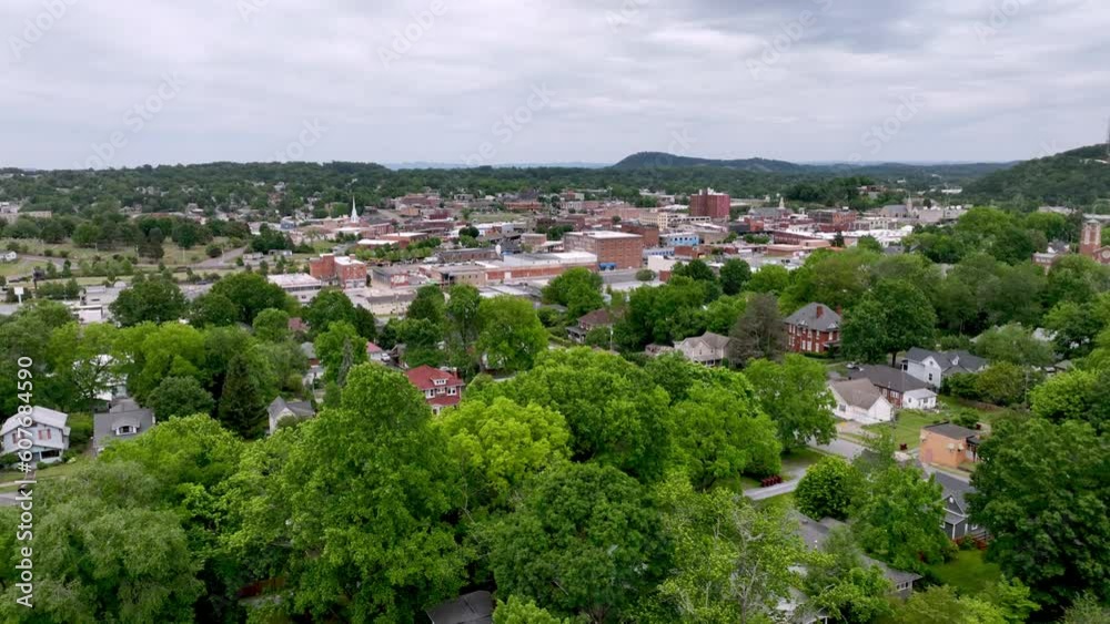 Aerial push in to Johnson City Tennessee over the treetops and neighborhoods, small town america