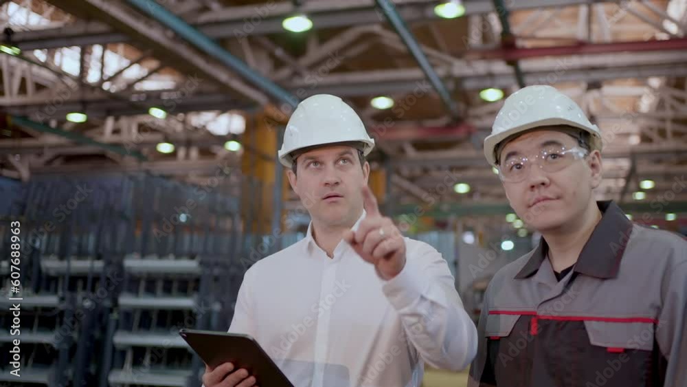Engineer asian caucasian man Discussing at Heavy industry plant using Technology tablet computer. Professional worker Hard Hat Industrial Specialist checking production metal construction Manufacture Engineer asian caucasian man Discussing at Heavy industry plant using Technology tablet computer. Professional worker Hard Hat Industrial Specialist checking production metal construction Manufacture