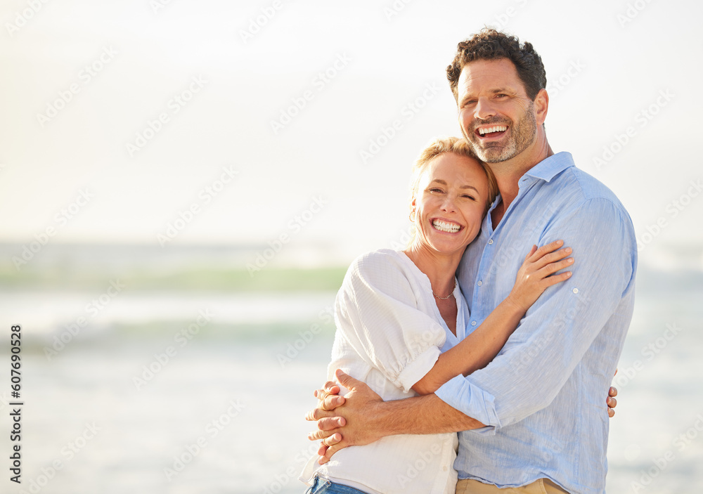Obraz premium Happy couple hug on beach, love and travel with anniversary vacation, tourism and mockup space. Happiness, trust and commitment with man and woman on tropical holiday, ocean and affection outdoor