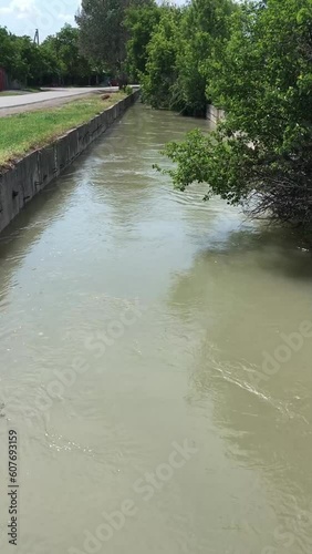 City water dranaige channel with water flow. Vertical Footage