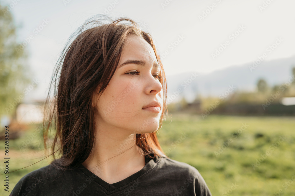 Contemplative girl with long hair in field Contemplative girl with long hair in field