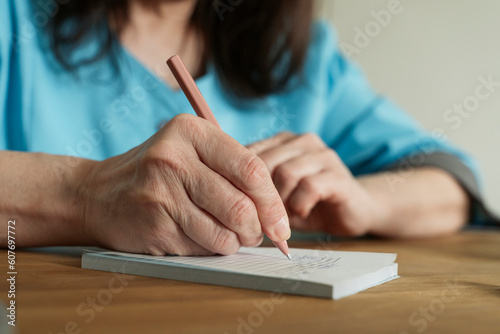 Doctor writing prescription with pen at medical practice photo