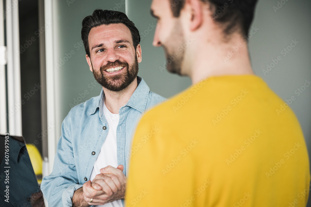 Smiling businessman looking at colleague in office