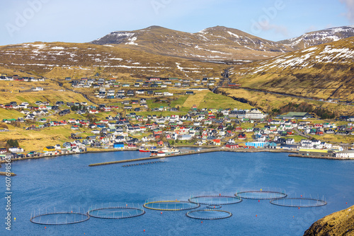 Salmon fish farm with townscape and mountains in Vestmanna, Faroe Islands photo