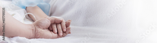 Little hands of not well girl falls into mother of doctor hands  Comforting. Recover little child hand lying in hospital bed sleeping. Health care medical emotional sickness family moment background