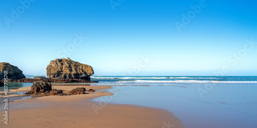 beach with rock on a sunny blue sky day © magann