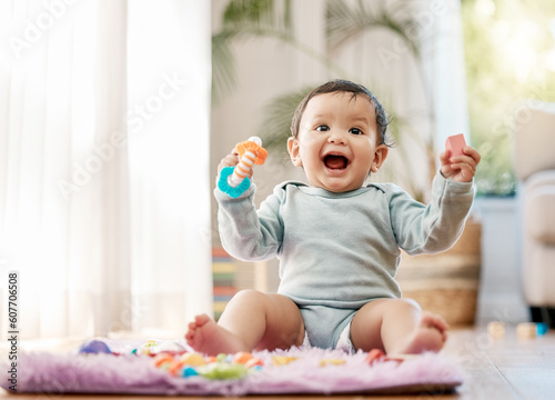 Portrait, smile and happy baby with toys on floor for fun, playing and game at home. Face, excited and toddler boy with creative building blocks for child development, learning or play in living room