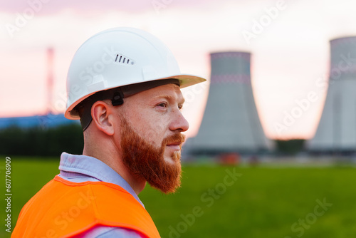 Portrait of a man in a white protective helmet and a reflective orange vest. Professional engineer