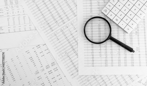 Calculator and magnifying glass on financial documents. Financial and business concept.