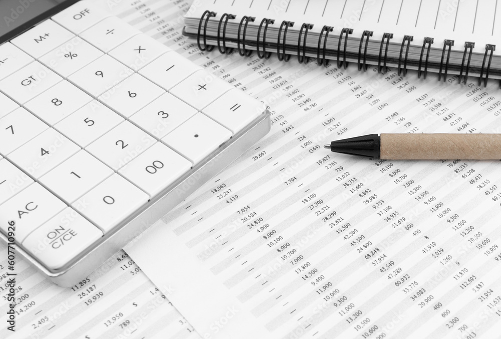 Calculator with notebook and pen on financial statement. Financial concept. Calculator with notebook and pen on financial statement. Financial concept.