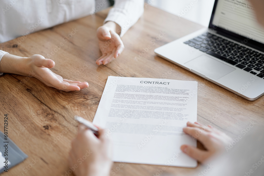 Business people signing contract papers while sitting at the wooden table in office, closeup. Partners or lawyers working together at meeting. Teamwork, partnership, success concept. Business people signing contract papers while sitting at the wooden table in office, closeup. Partners or lawyers working together at meeting. Teamwork, partnership, success concept.