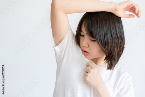 Woman raising her arms because of sweating under armpits.