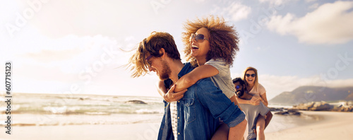 Canvas Print Couple enjoys a piggyback ride at the beach in summer